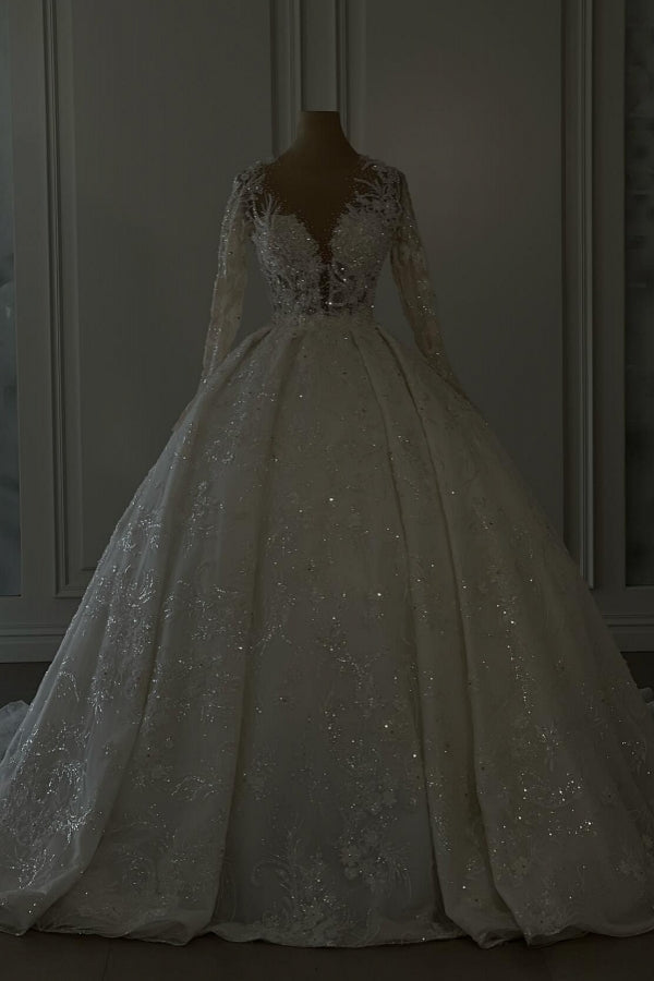 Vestido de novia largo de encaje color marfil, corte en A, escote en V, mangas largas y brillo, con lentejuelas.