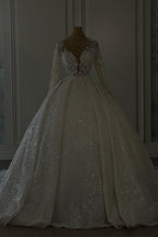 Vestido de novia largo de encaje color marfil, corte en A, escote en V, mangas largas y brillo, con lentejuelas.