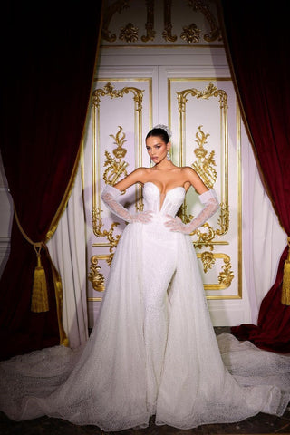 Lujoso vestido de novia largo color marfil, corte sirena, sin mangas, con escote en V, lentejuelas y pedrería, con cola desmontable.