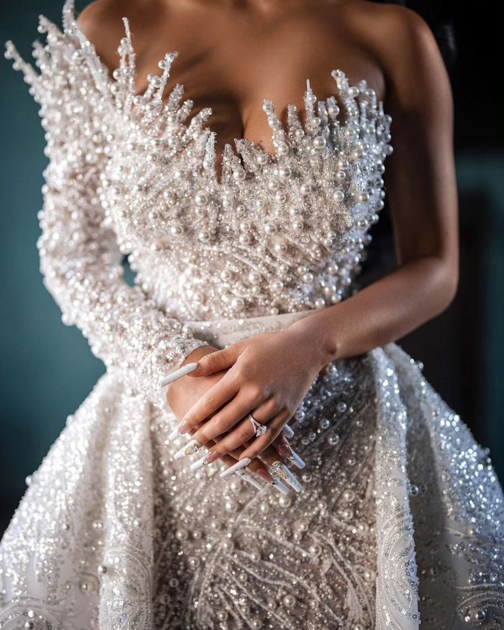 Luxueuse robe de mariée blanche longue asymétrique à une épaule, ornée de perles et de broderies, avec traîne.