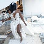 Robe de mariée blanche longue et luxueuse, asymétrique, sans manches, ornée de bijoux et avec traîne amovible.