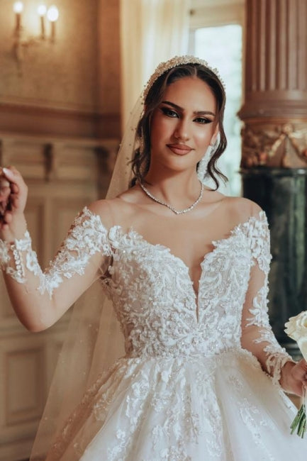 Robe de mariée luxueuse en tulle et dentelle blanche, longue, à col rond et manches longues.