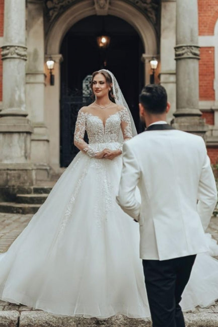 Robe de mariée luxueuse en tulle et dentelle blanche, longue, à col rond et manches longues.