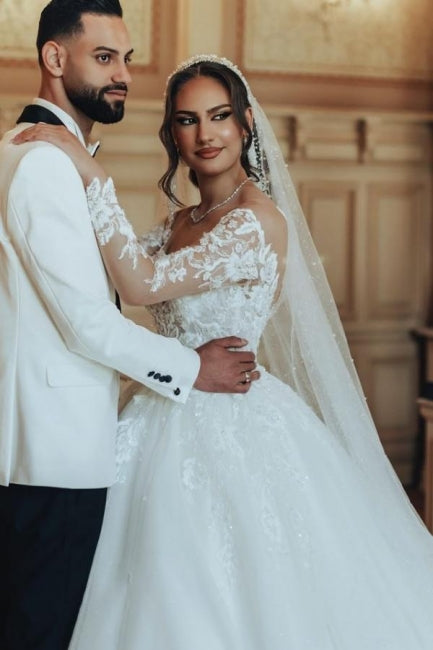 Robe de mariée luxueuse en tulle et dentelle blanche, longue, à col rond et manches longues.