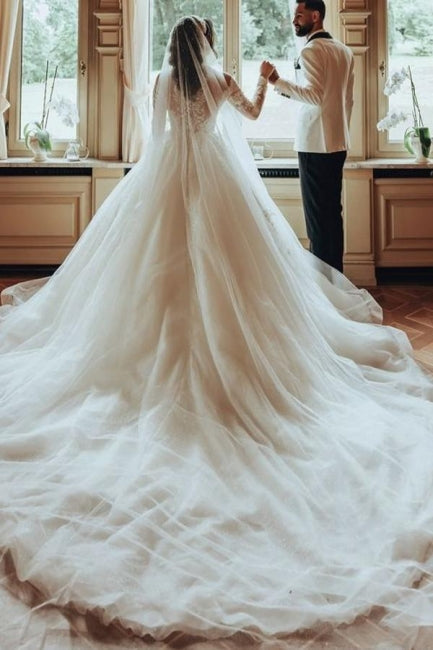 Robe de mariée luxueuse en tulle et dentelle blanche, longue, à col rond et manches longues.