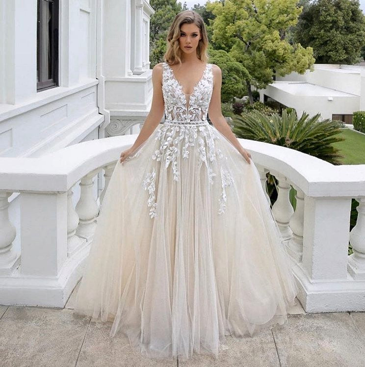 Vestido de novia largo de lujo, corte en A, escote en V, tul sin mangas, espalda descubierta y encaje.