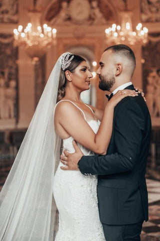 Robe de mariée sirène longue de luxe à fines bretelles et paillettes, ornée de dentelle.