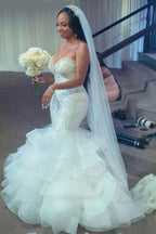 Robe de mariée sirène longue de luxe, bustier cœur, volants, perles et cristaux