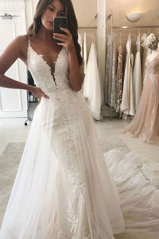 Vestido de novia estilo sirena con escote en V, tirantes y cola desmontable.