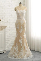 Robe de mariée sirène/trompette en dentelle, tulle et satin, bretelles classiques, transparente, col rond et traîne chapelle, bretelles régulières. 