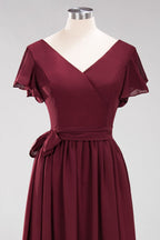Robe de demoiselle d'honneur élégante en mousseline de soie, coupe trapèze, col en V, manches courtes et ceinture à nœud. Longue robe de soirée.