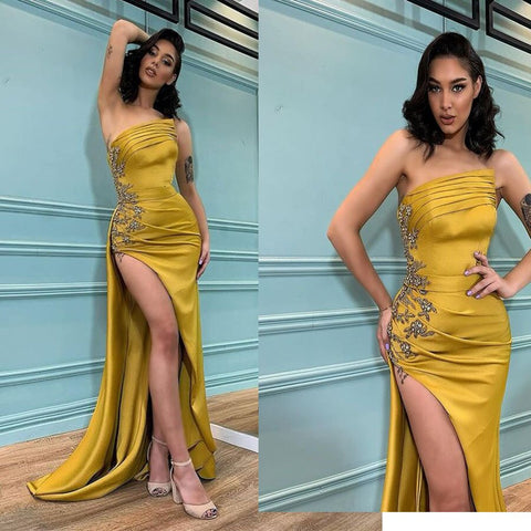 Vestido de noche moderno estilo sirena con apliques, abertura y sin tirantes.