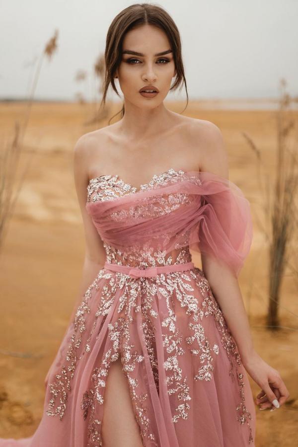 Robe de bal longue en tulle et dentelle, coupe trapèze, sans bretelles et fendue.