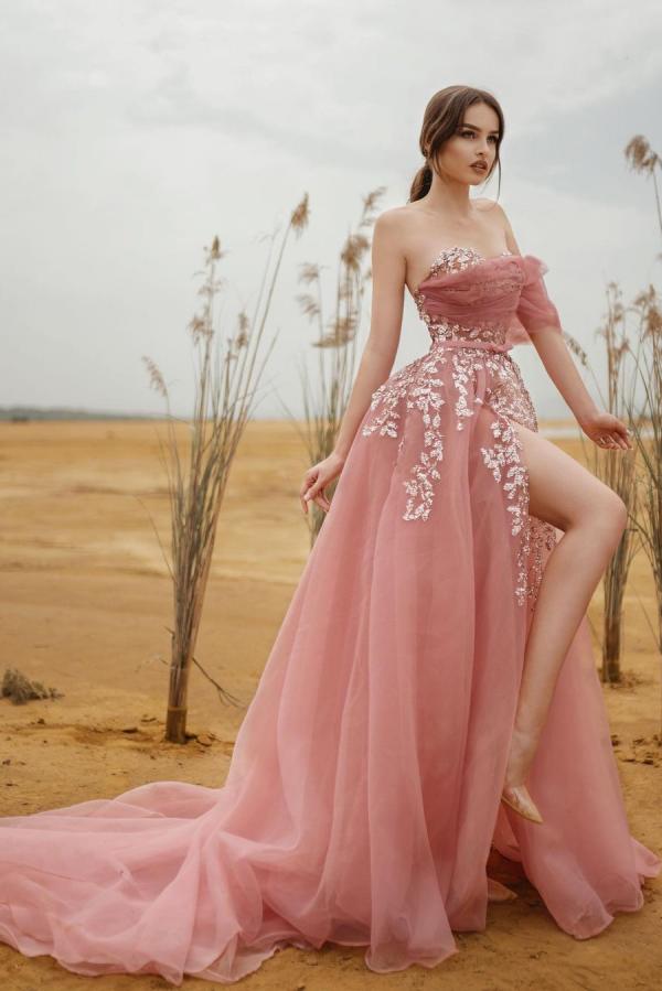 Robe de bal longue en tulle et dentelle, coupe trapèze, sans bretelles et fendue.