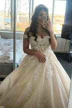 Robe de mariée princesse en tulle, coupe trapèze, épaules dénudées, style modeste, ornée de dentelle.