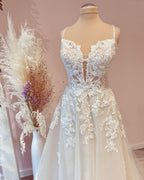 Vestido de novia de tul, corte modesto, largo, de línea A, con tirantes finos y apliques de encaje.