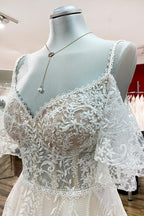 Vestido de novia modesto, largo, de corte A, escote corazón, tul, apliques de encaje y mangas.