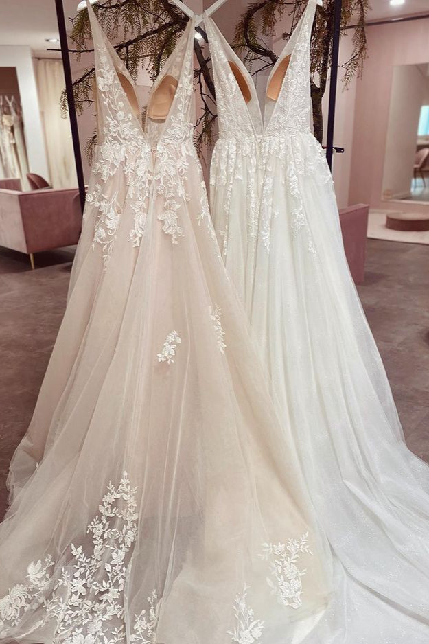 Robe de mariée sobre, longue, trapèze, dos nu, en tulle et dentelle, col V et décolleté en V.