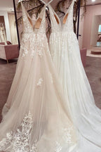 Robe de mariée sobre, longue, trapèze, dos nu, en tulle et dentelle, col V et décolleté en V.