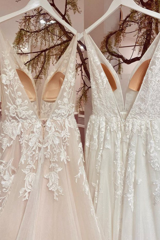 Robe de mariée sobre, longue, trapèze, dos nu, en tulle et dentelle, col V et décolleté en V.
