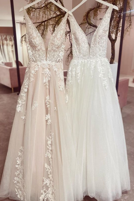 Robe de mariée sobre, longue, trapèze, dos nu, en tulle et dentelle, col V et décolleté en V.