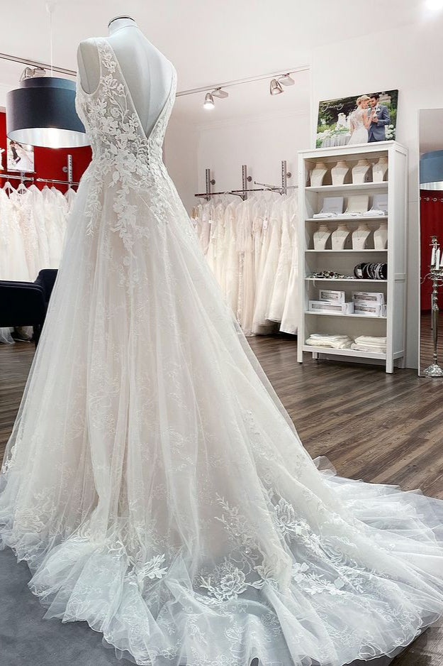 Robe de mariée en tulle, coupe trapèze, dos nu et décolleté en V, ornée d'appliqués de dentelle. Sage et élégante.