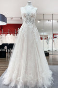 Robe de mariée en tulle, coupe trapèze, dos nu et décolleté en V, ornée d'appliqués de dentelle. Sage et élégante.
