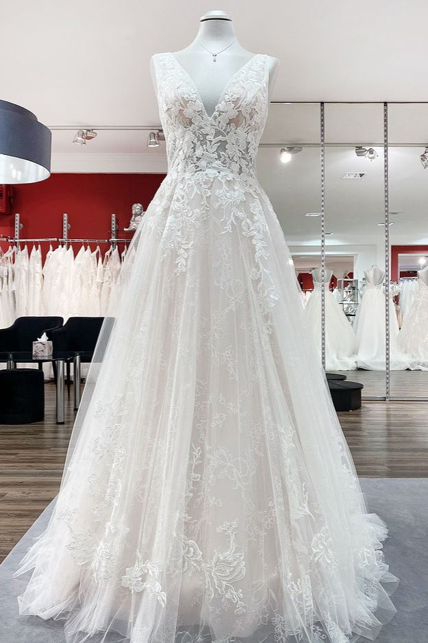 Robe de mariée en tulle, coupe trapèze, dos nu et décolleté en V, ornée d'appliqués de dentelle. Sage et élégante.
