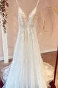 Vestido de novia de tul, modesto, largo, corte en A, escote en V, tirantes finos y apliques de encaje.