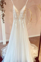 Vestido de novia de tul, modesto, largo, corte en A, escote en V, tirantes finos y apliques de encaje.