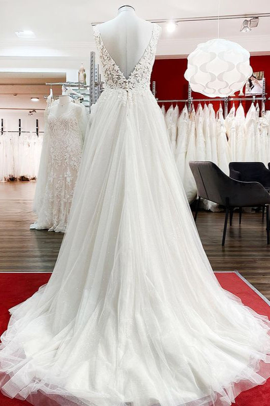 Robe de mariée sobre, longue, trapèze, col en V, en tulle à volants, dos nu et dentelle.
