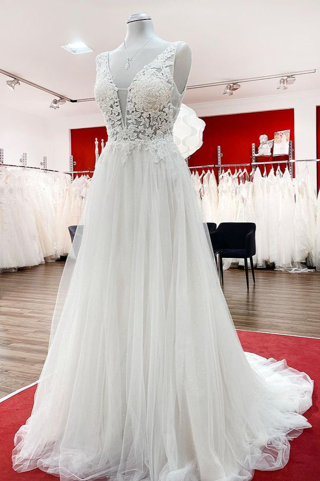 Robe de mariée sobre, longue, trapèze, col en V, en tulle à volants, dos nu et dentelle.