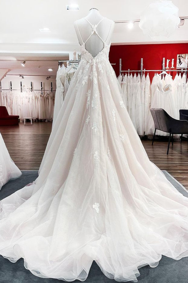 Robe de mariée princesse longue et sobre en tulle à fines bretelles et col en V, ornée de dentelle.