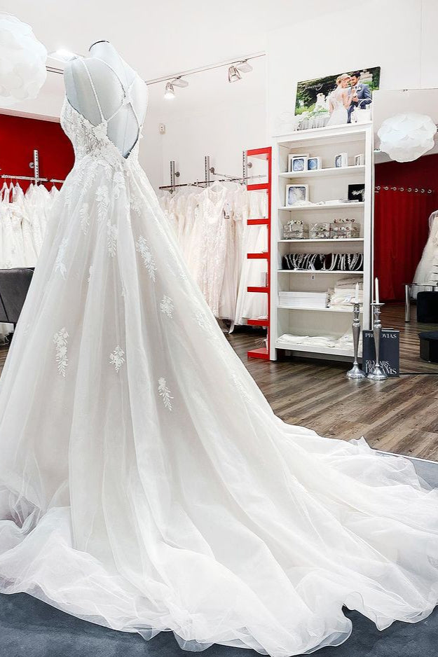 Robe de mariée princesse longue et sobre en tulle à fines bretelles et col en V, ornée de dentelle.