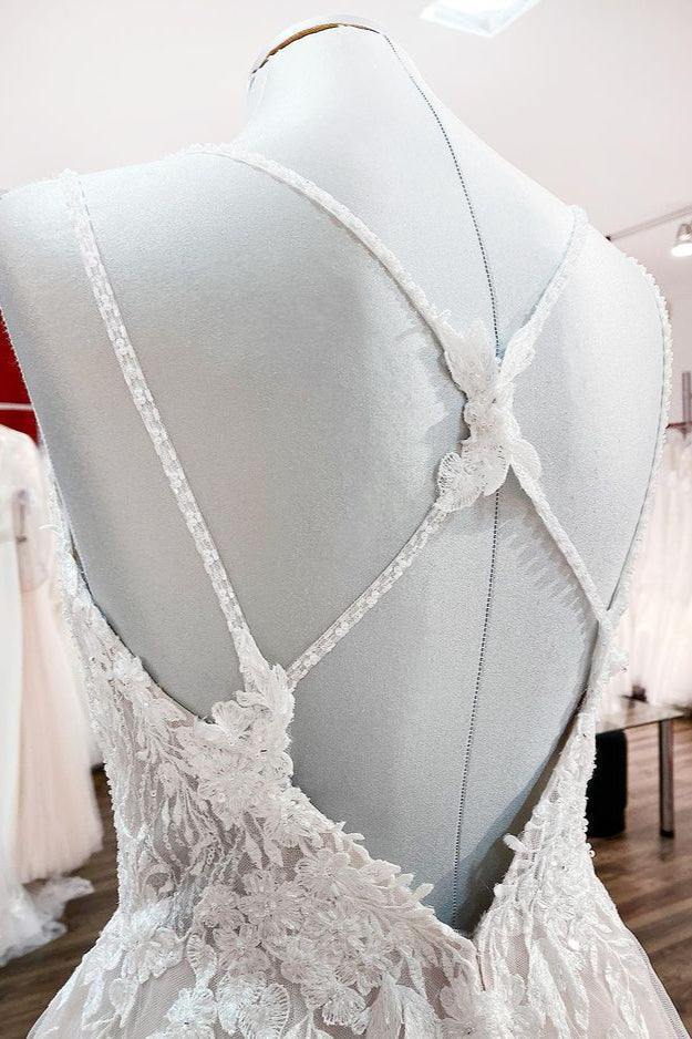 Robe de mariée princesse longue et sobre en tulle à fines bretelles et col en V, ornée de dentelle.