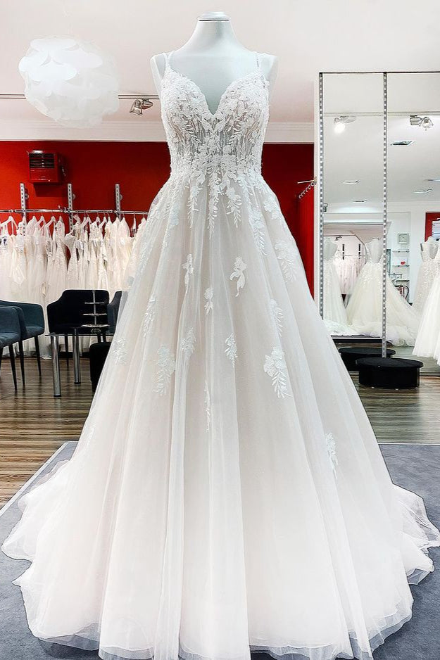 Robe de mariée princesse longue et sobre en tulle à fines bretelles et col en V, ornée de dentelle.