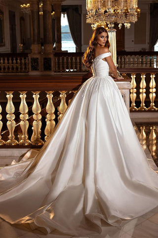 Robe de mariée en satin à épaules dénudées, sobre et élégante, avec traîne amovible. 