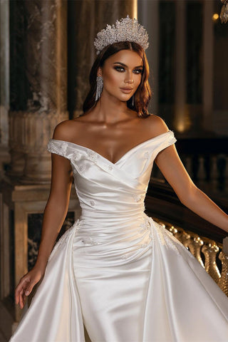 Robe de mariée en satin à épaules dénudées, sobre et élégante, avec traîne amovible. 