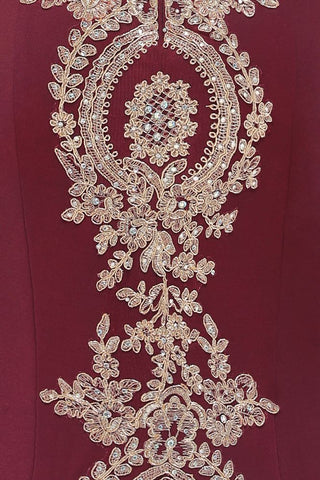 Vestido de noche de sirena con apliques dorados y hombros descubiertos, estilo ajustado.