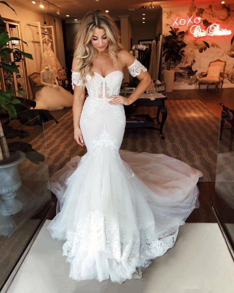 Vestido de novia de tul con hombros descubiertos, falda sirena con apliques y cola de barrido.