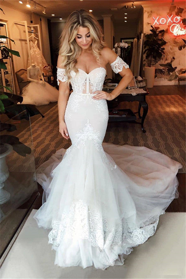 Vestido de novia de tul con hombros descubiertos, falda sirena con apliques y cola de barrido.