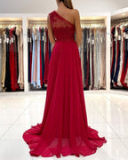 Vestido largo de fiesta rojo de un solo hombro, sin mangas y con abertura frontal.