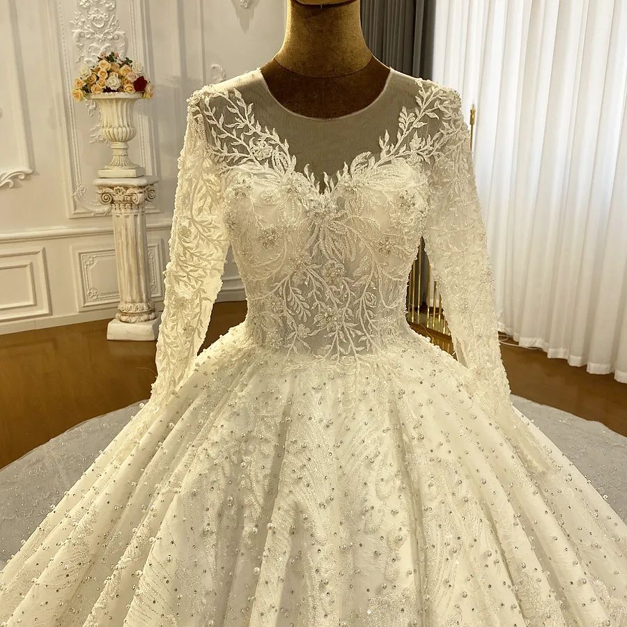 Robe de mariée princesse élégante en dentelle, coupe trapèze, manches longues et traîne