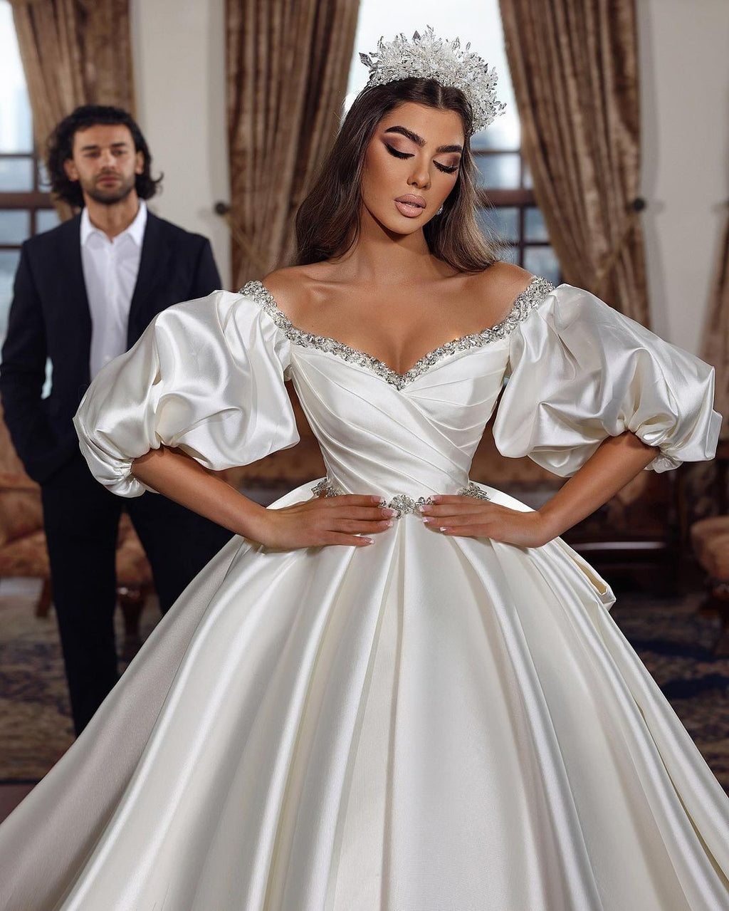 Robe de mariée princesse longue ivoire, coupe trapèze, col en V, ornée de bijoux et manches longues