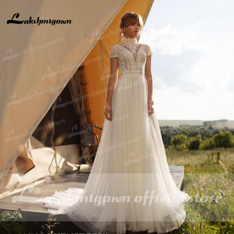 Vestido de novia vintage bohemio Baoleely, de encaje y tul, con cuello alto, mangas casquillo y corte en A. Elegante vestido de novia color marfil.