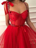 Robe de soirée longue rouge en tulle à perles et fleurs, coupe trapèze, idéale pour un bal de fin d'année ou une remise de diplômes.