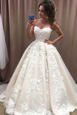 Vestido de novia largo y romántico con escote corazón y apliques florales 3D de encaje.