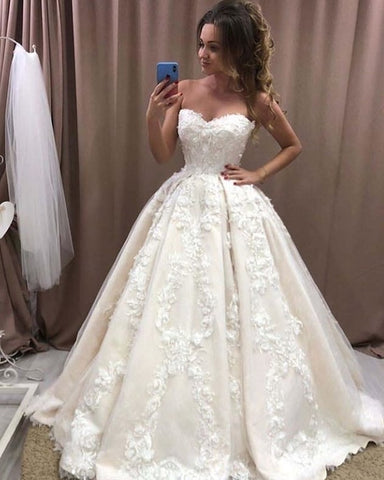 Vestido de novia largo y romántico con escote corazón y apliques florales 3D de encaje.