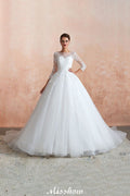 Robe de bal romantique en dentelle à manches longues, entièrement recouverte de tulle, boutons recouverts, coupe trapèze, traîne courte.