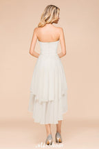 Robe de demoiselle d'honneur romantique blanche/ivoire à décolleté cœur asymétrique sans manches, idéale pour un mariage de plage.